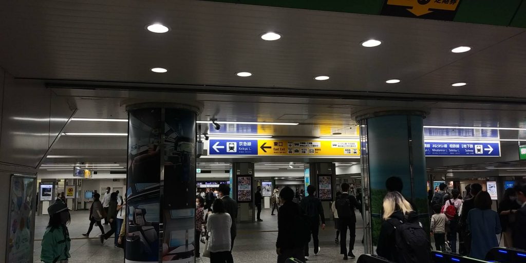 横浜駅中央改札を出たところ。通路の画像。通路頭上には色々な案内板の掲示。数人が行き来。
